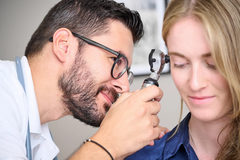 Doktor huus arzt untersucht ohr von patientin